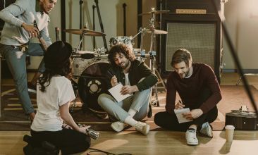 An artist and producer in deep conversation in a recording studio.