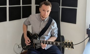 Dmytro Babichev playing an ESP LTD EC-1000 electric guitar in a home recording studio with acoustic foam panels.
